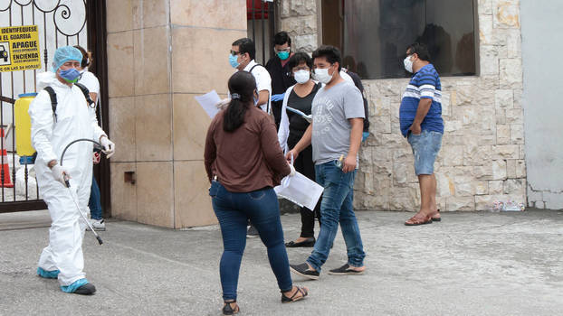 [Translate to en:] Der Eingangsbereich eines Krankenhauses in der Stadt Guayaquil wird am 28. März 20202 desinfiziert.