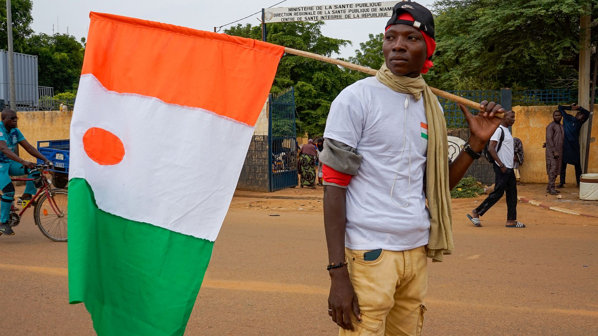 Ein Anhänger der Militärjunta hält eine nigrische Flagge während einer Demonstration gegen eine mögliche Militärintervention in Niamey, Niger, 20. August 2023