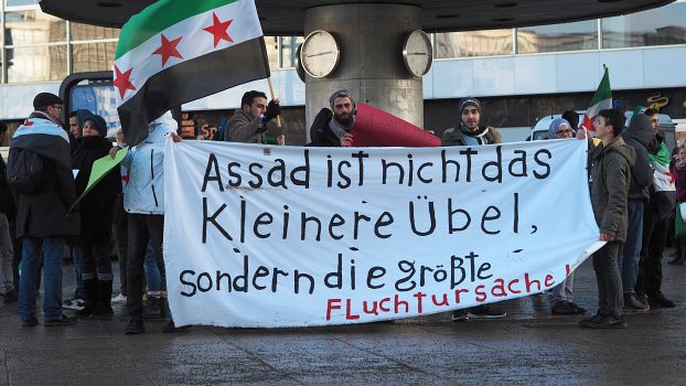 Syrische Aktivist*innen protestieren vor der Weltzeituhr in Berlin