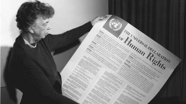 Eleanor Roosevelt mit einem Poster der Allgemeinen Erklärung der Menschenrechte (in englischer Sprache), Lake Success, New York, ca. November 1949.