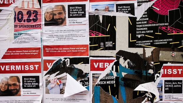 Auf einer Baustelle in Berlin, Deutschland kleben Flugblätter an einer Wand, auf denen vermisste Personen abgebildet sind, die von der Hamas in Israel entführt wurden (25.10.2023)