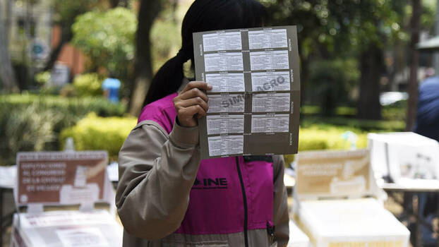 Eine Frau hält einen Probe-Stimmzettel für die Zwischenwahlen im Juni 2021 in Mexiko ins Bild. Mit Hilfe der Probe-Stimmzettel wird das Wahlverfahren erklärt. Bild: Maria Ruiz. Pie de Página. 