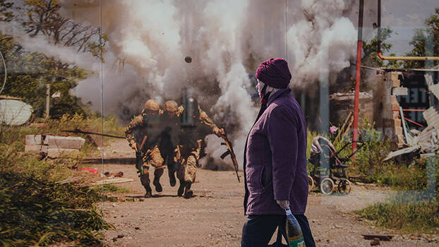 Passantin vor einem Fotomahnmal der Kämpfe zwischen ukrainischem Militär und Separatisten