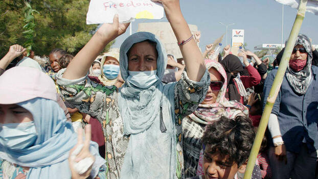Demonstation. Viele Frauen mit Kopftüchern und Mund-Nasen-Schutz sind zu sehen. Einige halten Schilder hoch. Im Mittelpunkt Frau mit hellblauem Kopftuch, auf ihrem Schild (abgeschnitten) steht "Freedom".