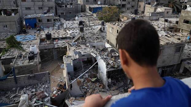 A boy looks at rubble of buildings destroyed in Israeli airstrikes in the southern Gaza Strip city of Khan Younis.