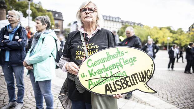  Frau auf ver.di-Kundgebung in Wiesbaden am 20.9.2022 mit Transparent: Gesundheits- und Krankenpflege Ausbeutung