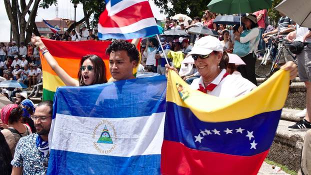 Costa Rica, San José, 25.8.2018: Bei einer Demonstration gegen Ausländerfeindlichkeit und für die Unterstützung der Geflüchteten aus Nicaragua halten Menschen Fahnen von Nicaragua und Venezuela hoch. 