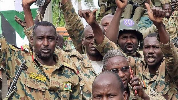 Soldaten der sudanesischen Armee, die dem Armeechef Abdel Fattah al-Burhan treu ergeben sind, feiern, nachdem sie einen Militärstützpunkt in der Stadt Nyala zurückerobert haben, der von den rivalisierenden Rapid Support Forces (RSF) eingenommen worden war.