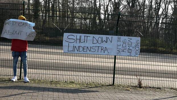 Eine Frau hält ein Plakat, um auf die beengte Wohnsituation der Geflüchteten in der Corona-Pandemie aufmerksam zu machen. «Shut down Lindenstraße. Save the kids, women and youth» steht auf dem Plakat. 