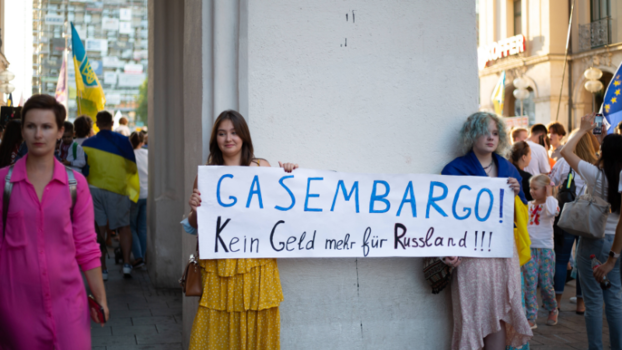 Zwei junge Frauen halten ein Schild hoch, auf dem "Gasembargo" zu sehen ist.