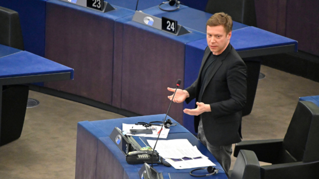 Martin Schirdewan, ein weißer Mann, steht vor einem Mikro im Plenarsaal des Europäischen Parlaments.