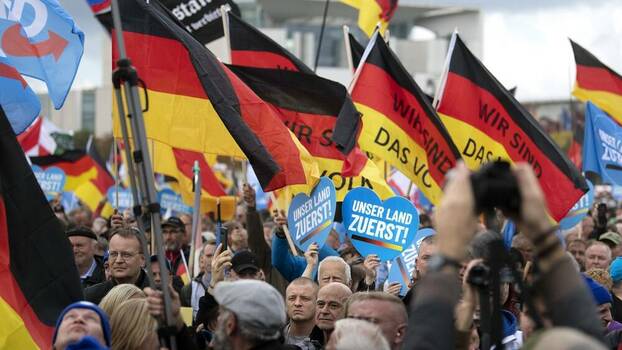 Menschen versammeln sich mit Deutschland-Fahnen vor dem Reichstag.