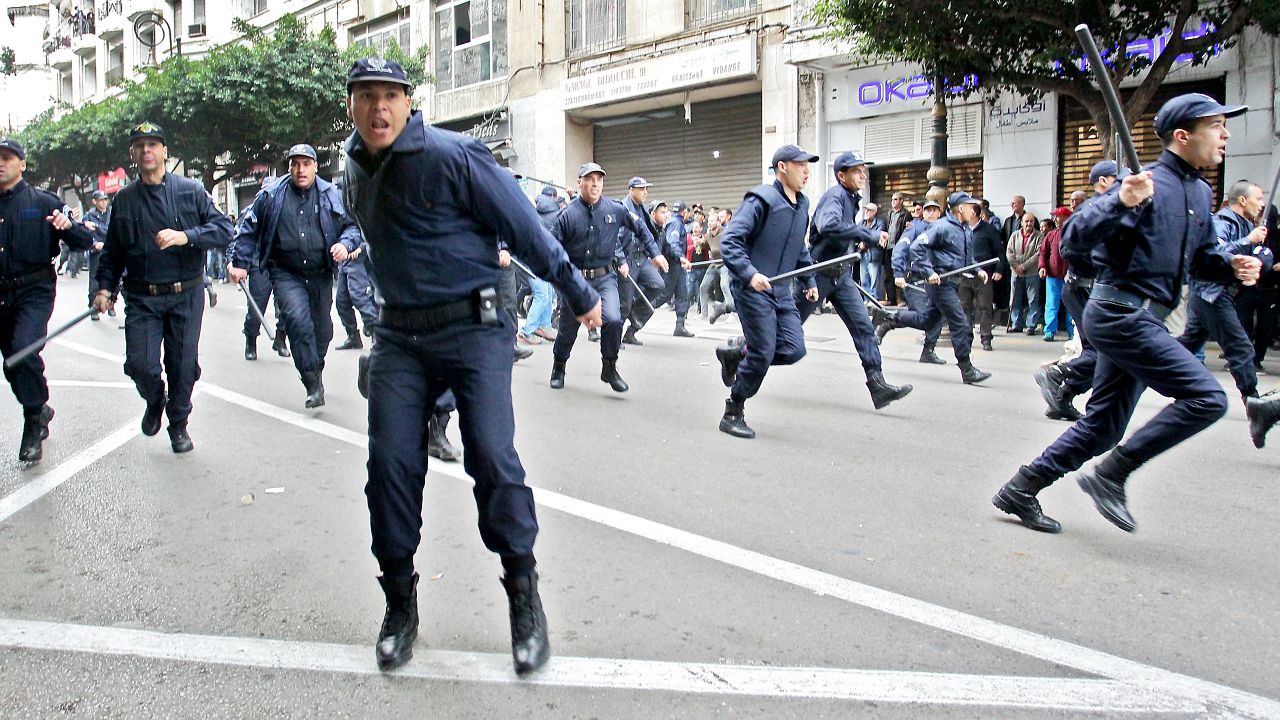 Algerian security forces run to disperse protesters during an anti-government demonstration in the capital Algiers on December 12, 2019 during the presidential election